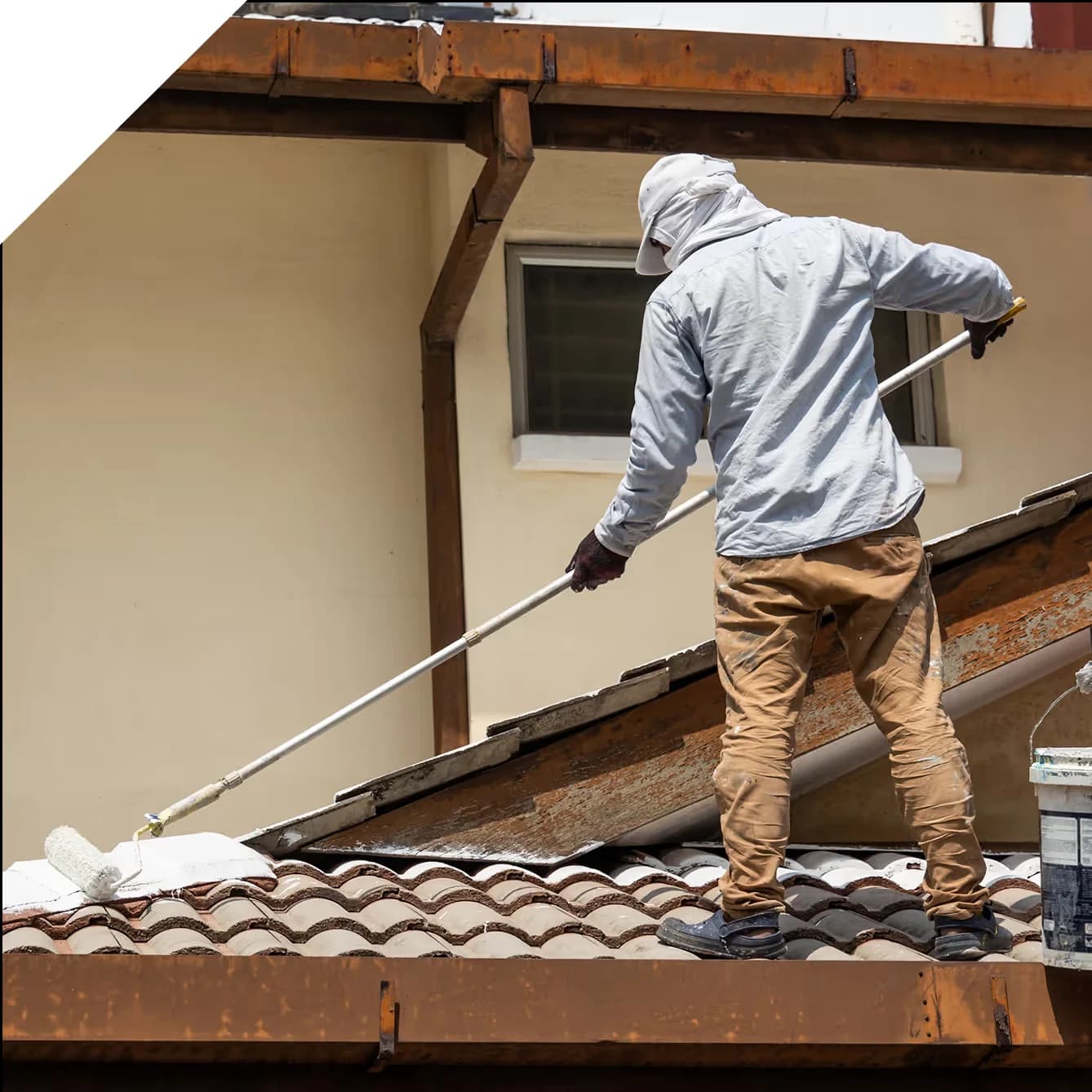 worker cleaning a shingled residential roof